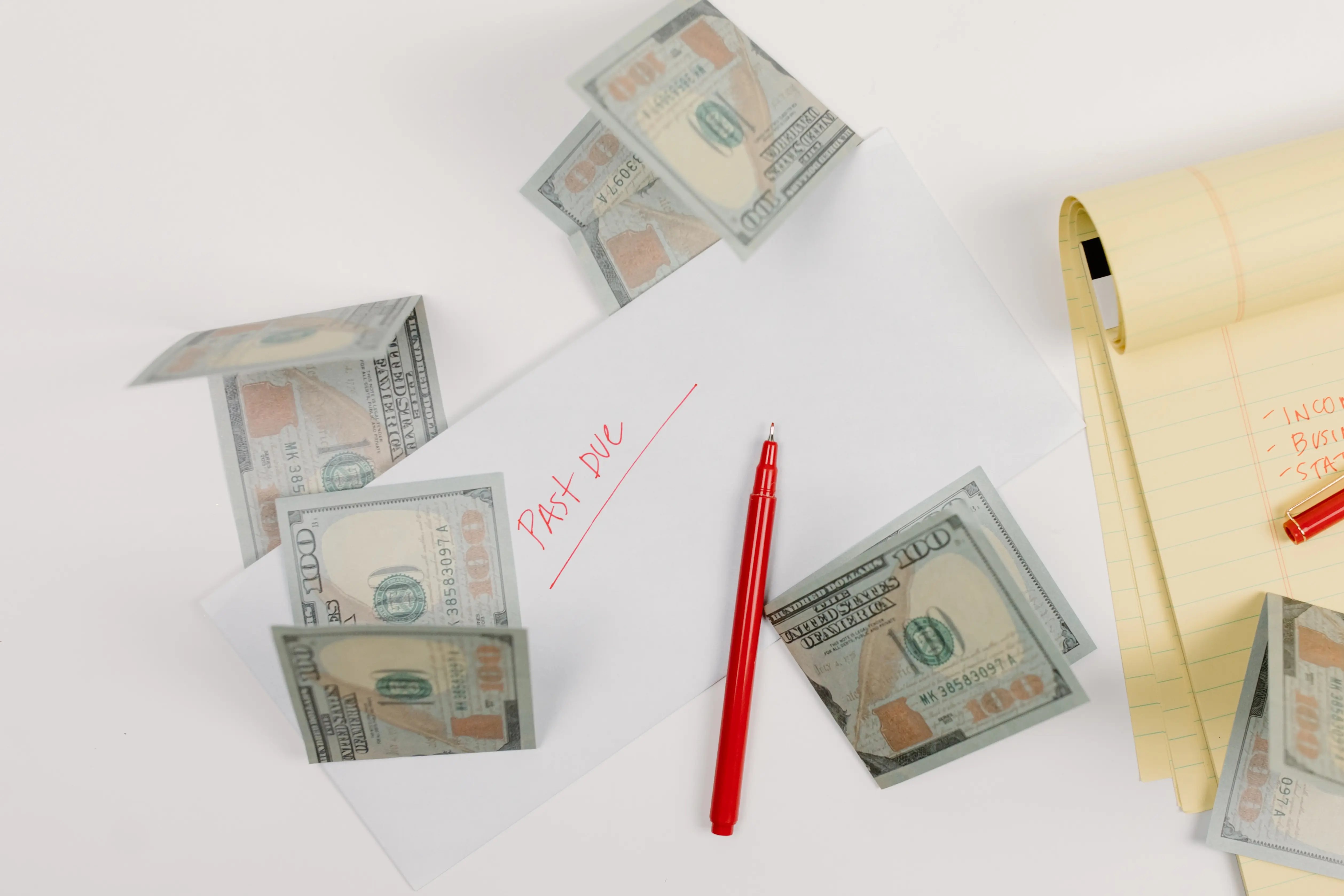 Photo de Tara Winstead représentant des billets de $100 utilisés pour payer des factures et placés dans une enveloppe comportant la mention "Past Due"